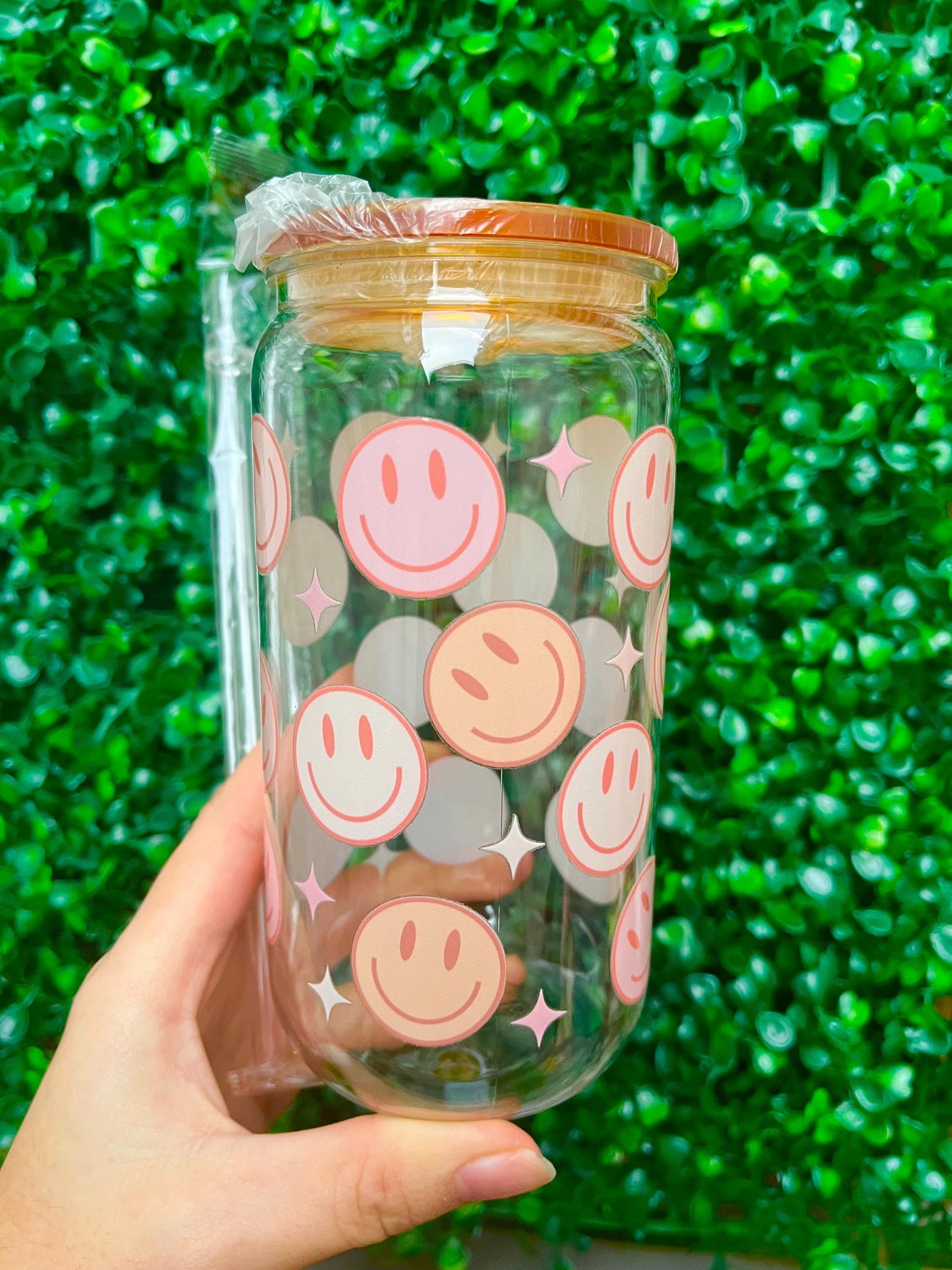 Pastel orange and pink smiley face 16oz plastic beer can tumbler cup with coloured lid and reusable plastic straw.